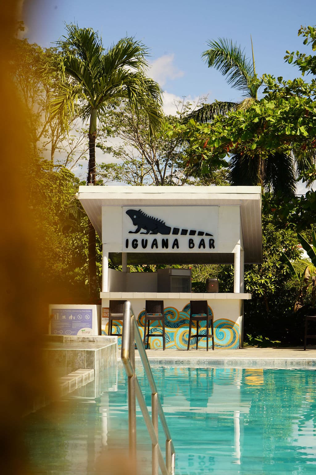 Iguana Bar's poolside palapa across the turquoise pool by day