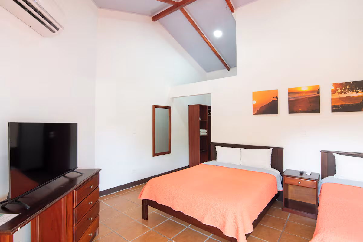 Habitación estándar de techo abovedado con dos camas, televisor y clóset