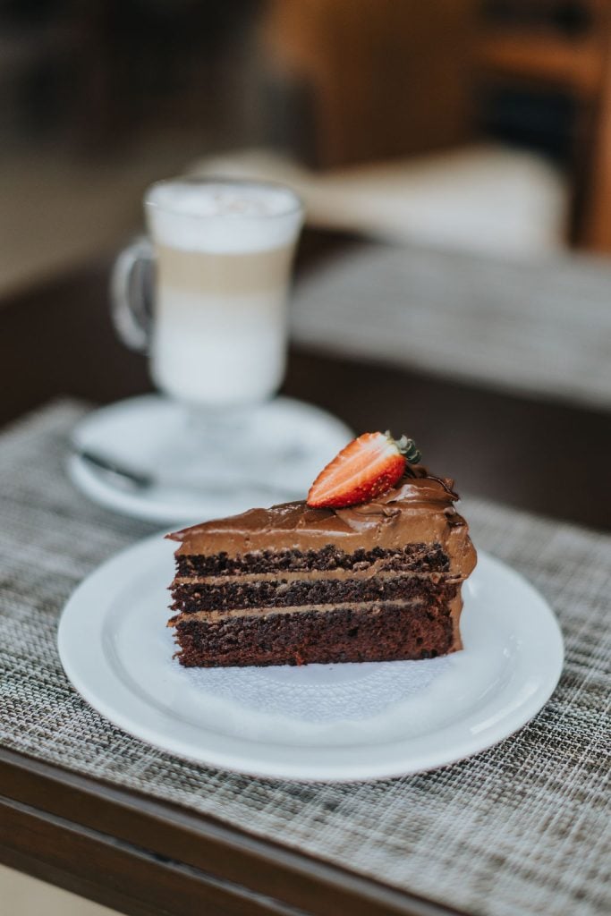 A slice of chocolate cake with a coffee