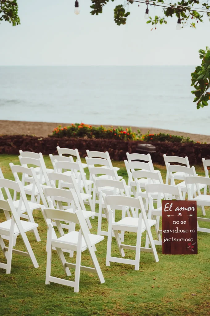 Sillas blancas alineadas frente al mar antes de la ceremonia