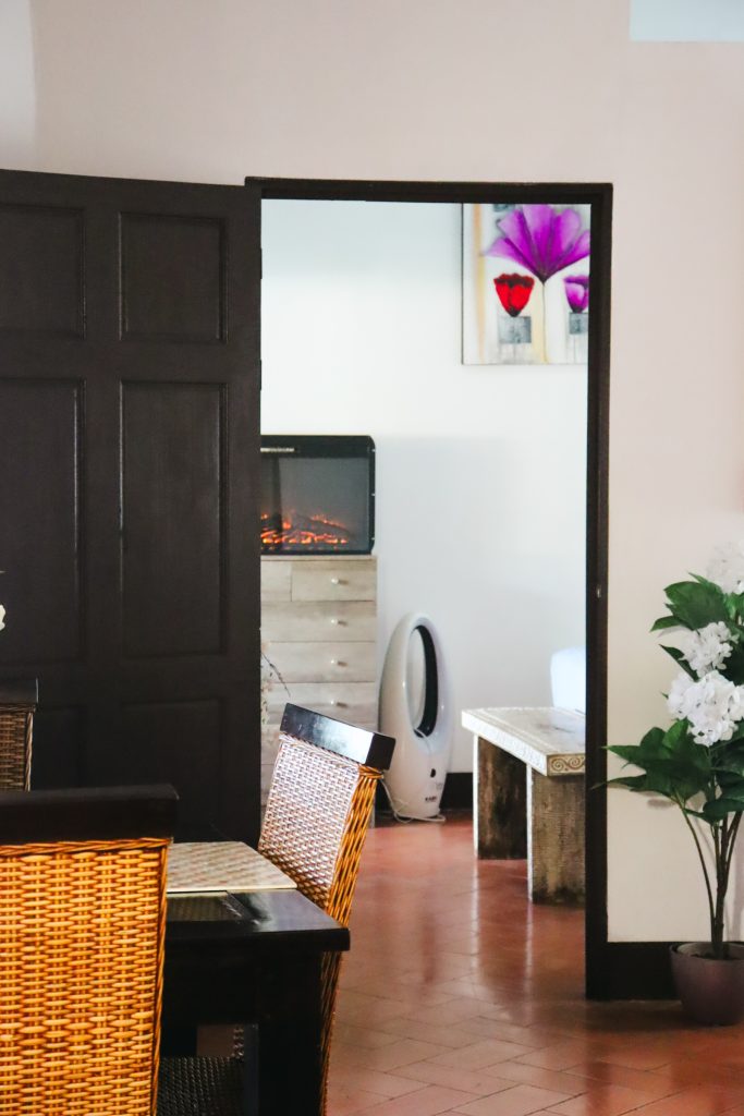 Looking towards the villa living and dining area, with an electric fireplace and wicker table