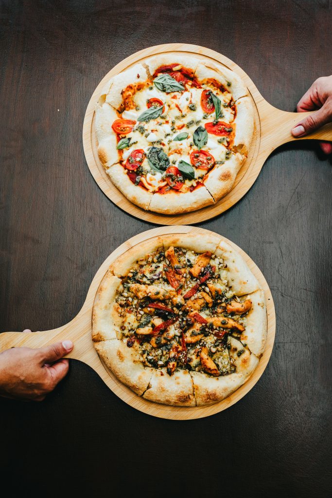 Las manos del pizzaiolo estirando la masa artesanal